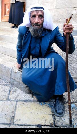 Un uomo palestinese anziano che fuma la sigaretta nel quartiere musulmano della città vecchia di Gerusalemme. Foto Stock