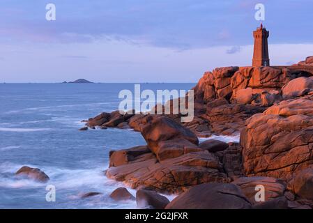 Il faro Men Ruzé e la costa rocciosa di Ploumanac'h brillano alla luce del sole che tramonta, Côte de Granit Rose, Francia, Bretagna, Côtes d´Armor, vicino Perros-Guirec Foto Stock