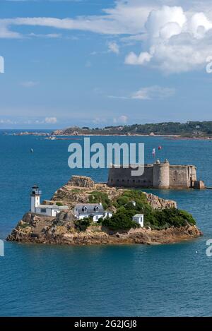 Ile Louët con faro e casa del custode, sullo sfondo Château Taureau, vicino a Carantec nella baia di Morlaix, Francia, Bretagna, dipartimento del Finistère Foto Stock