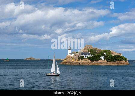 Barca a vela di fronte all'Ile Louët con faro e casa del custode, a Carantec nella baia di Morlaix, Francia, Bretagna, dipartimento del Finistère Foto Stock