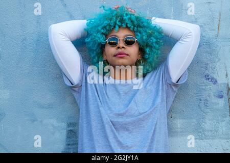 ritratto di donna afro-americana latina con occhiali da sole sulla parete Foto Stock