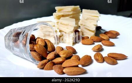 Badam Katli è un dolce indiano a forma di diamante con mandorle fatte usando mandorle, zucchero e mava, servito in un piatto isolato su sfondo bianco. Selettivo Foto Stock