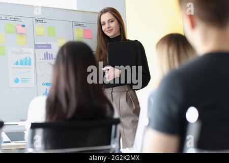 Donna business coach in piedi in lavagna di fronte agli ascoltatori studenti Foto Stock