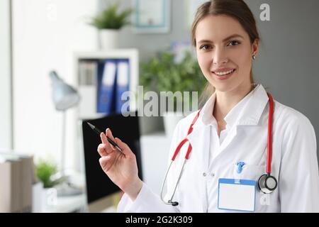Ritratto di sorridente dottore con penna a sfera e stetoscopio sul collo Foto Stock