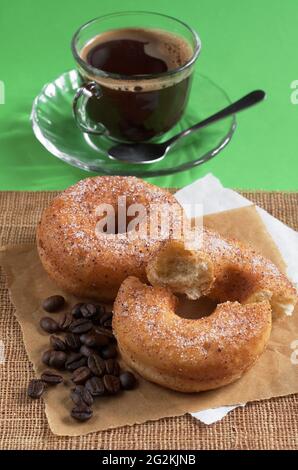 Ciambelle classiche con tazza di caffè caldo per la colazione sul tavolo Foto Stock