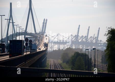 10 giugno 2021, Amburgo: I camion e le auto passano sul ponte Köhlbrand nel porto di Amburgo, mentre le piste ferroviarie accanto per i treni merci e le gru a portale per container al terminal dei container Eurogate a Waltershof sono visibili. Foto: Jonas Walzberg/dpa Foto Stock