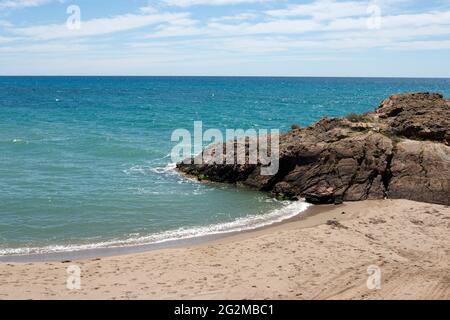 Separazione della spiaggia dalle formazioni rocciose tranquilla e solitaria a Bolnuevo, Mazarron, Murcia, Spagna. Foto Stock