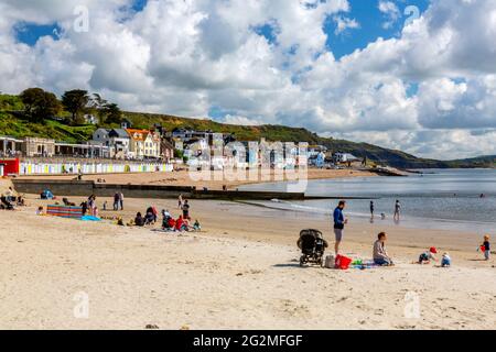 Case colorate affacciate sul mare e caffè sopra la spiaggia di Lyme Regis sulla Jurassic Coast, Dorset, Regno Unito Foto Stock