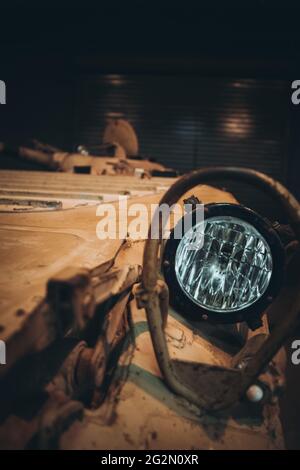 Primo piano di un faro di un portaerei corazzato russo, dipinto in camo arancione nel deserto. APC offuscato sullo sfondo, concetti di guerra e pettine Foto Stock