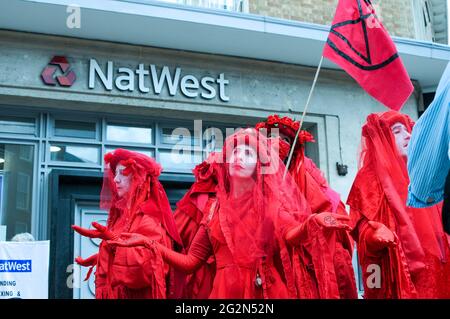 Cambridge, Regno Unito, Inghilterra, 12-062021, gli attivisti XR hanno svolto una meditazione in banca, mentre altri hanno organizzato spettacoli per la strada fuori. I Banners fatti in casa hanno letto 'Barclays: The Ecocide Bank', 'HSBC: Siamo crisi climatica', 'Lloyds Bank: Ramping Up Fossil Investment', 'NatWest: Funding Fracking and Tar Sands' e 'Santander: Perché i nostri azionisti sono più importanti di voi'. Anche una band samba si è unita nella protesta Foto Stock