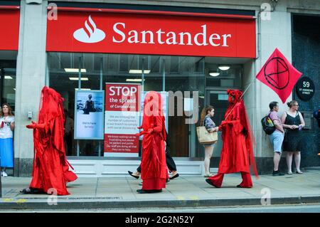 Cambridge, Regno Unito, Inghilterra, 12-062021, gli attivisti XR hanno svolto una meditazione in banca, mentre altri hanno organizzato spettacoli per la strada fuori. I Banners fatti in casa hanno letto 'Barclays: The Ecocide Bank', 'HSBC: Siamo crisi climatica', 'Lloyds Bank: Ramping Up Fossil Investment', 'NatWest: Funding Fracking and Tar Sands' e 'Santander: Perché i nostri azionisti sono più importanti di voi'. Anche una band samba si è unita nella protesta Foto Stock