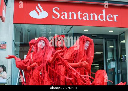 Cambridge, Regno Unito, Inghilterra, 12-062021, gli attivisti XR hanno svolto una meditazione in banca, mentre altri hanno organizzato spettacoli per la strada fuori. I Banners fatti in casa hanno letto 'Barclays: The Ecocide Bank', 'HSBC: Siamo crisi climatica', 'Lloyds Bank: Ramping Up Fossil Investment', 'NatWest: Funding Fracking and Tar Sands' e 'Santander: Perché i nostri azionisti sono più importanti di voi'. Anche una band samba si è unita nella protesta Foto Stock