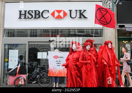 Cambridge, Regno Unito, Inghilterra, 12-062021, gli attivisti XR hanno svolto una meditazione in banca, mentre altri hanno organizzato spettacoli per la strada fuori. I Banners fatti in casa hanno letto 'Barclays: The Ecocide Bank', 'HSBC: Siamo crisi climatica', 'Lloyds Bank: Ramping Up Fossil Investment', 'NatWest: Funding Fracking and Tar Sands' e 'Santander: Perché i nostri azionisti sono più importanti di voi'. Anche una band samba si è unita nella protesta Foto Stock