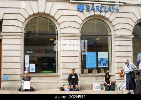 Cambridge, Regno Unito, Inghilterra, 12-062021, gli attivisti XR hanno svolto una meditazione in banca, mentre altri hanno organizzato spettacoli per la strada fuori. I Banners fatti in casa hanno letto 'Barclays: The Ecocide Bank', 'HSBC: Siamo crisi climatica', 'Lloyds Bank: Ramping Up Fossil Investment', 'NatWest: Funding Fracking and Tar Sands' e 'Santander: Perché i nostri azionisti sono più importanti di voi'. Anche una band samba si è unita nella protesta Foto Stock