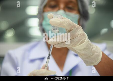 Bangkok, Thailandia. 12 giugno 2021. Un operatore sanitario prepara una dose del vaccino AstraZeneca COVID-19 durante una campagna di vaccinazione della popolazione contro il Covid-19. Sul progresso della vaccinazione, il Ministero della Sanità pubblica ha riferito, a partire da venerdì, 5.97 milioni di persone hanno ricevuto i vaccini. Il governo thailandese intende inoculare 50 milioni di persone, ovvero il 70% della popolazione, entro la fine dell'anno. (Foto di Yuttachai Kongprasert/SOPA IMA/Sipa USA) Credit: Sipa USA/Alamy Live News Foto Stock