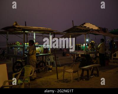 MUMBAI, INDIA - 30 dicembre 2021: I falkers vendono spuntini di strada e fast food sulla spiaggia indiana. Le famiglie trascorrono il tempo libero sulle spiagge. Foto Stock