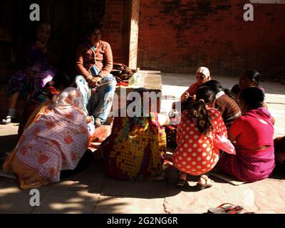 Vita e stile di vita delle donne nepali le persone che siedono si uniscono a parlare di gruppo al piano di mattina all'aperto nella città vecchia di thamel a Basantapur Katmandu durbar squara Foto Stock