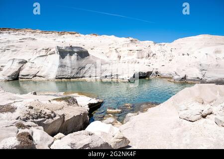 Isola di Milos, Cicladi Grecia. Sarakiniko spiaggia vulcanica bianco colore formazioni rocciose paesaggio lunare e turchese mare blu acqua. Vacanze estive viaggio de Foto Stock