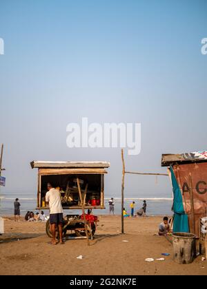 MUMBAI, INDIA - 30 dicembre 2021: I falkers vendono spuntini di strada e fast food sulla spiaggia indiana. Le famiglie trascorrono il tempo libero sulle spiagge. Foto Stock