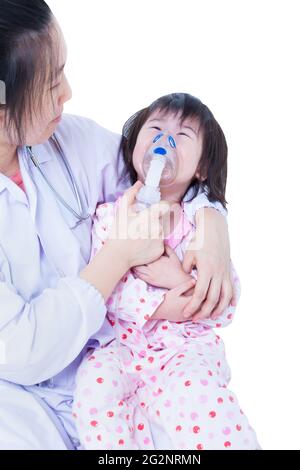 Il medico aiuta la bambina asiatica (thailandese) che prende le vie respiratorie, la terapia di inalazione, il bambino era bronchite e piangendo, isolato su sfondo bianco Foto Stock