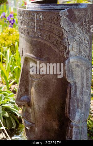 Una grande statua della testa utilizzata come fontana d'acqua nel popolare sito turistico dei giardini formali di Kittenberger Erlebnisgarten, bassa Austria, Austria Foto Stock