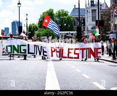 Londra, Regno Unito. 12 giugno 2021. I manifestanti marciano lungo Whitehall mentre tenevano un grande cartello con la scritta Long Live Palestine durante una manifestazione che chiede giustizia per la Palestina. Dal maggio 2021 Israele ha lanciato 11 giorni di bombardamenti aerei a Gaza, uccidendo 248 persone, di cui 66 bambini e lasciando più di 1,900 feriti. Inoltre, i bombardamenti di Hamas in Israele nello stesso periodo hanno ucciso 12 civili, tra cui due bambini. Molti gruppi pro-palestinesi hanno protestato nelle città di tutto il mondo. (Foto di Loredana Sangiuliano/SOPA Imag/Sipa USA) Credit: Sipa USA/Alamy Live News Foto Stock