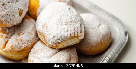 Berliner Pfannkuchen, una ciambella tedesca, tradizionale impasto di lievito fritto in profondità riempito con crema di cioccolato e cosparso di zucchero in polvere, dolcezza su a. Foto Stock