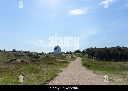 Una vista della chiesa di Der Tilsandede Kirke vicino Skagen sepolto tra le dune di sabbia e la vegetazione Foto Stock