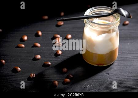 Affogato di vaniglia condito con caffè caldo su fondo di legno nero Foto Stock