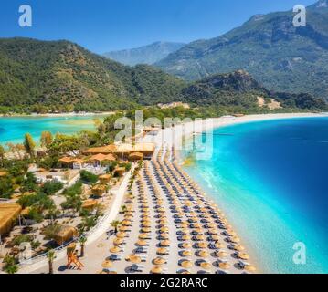 Vista aerea della baia di mare e della spiaggia di sabbia con ombrelloni in estate Foto Stock