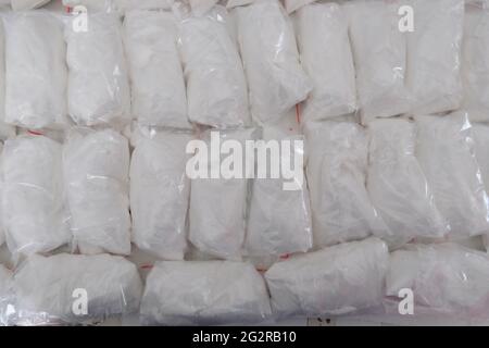 Un gran numero di bustine trasparenti riempite di polvere bianca. Polvere bianca confezionata in bustine piccole. Foto Stock