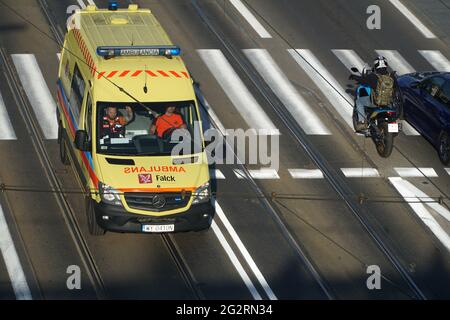 Varsavia, Polonia - 11 giugno 2021: Ambulanza gialla con luci lampeggianti in corsa sulla pista del tram per aggirare l'ingorgo nei pressi della città vecchia di Varsavia. Foto Stock