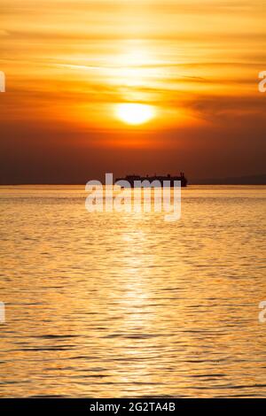 Il sole sta per scomparire dietro qualche nuvola-cover Foto Stock