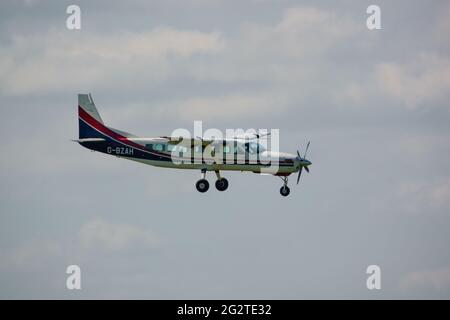 Una grande carovana cessna 208B torna a terra su una pista di erba dopo aver abbandonato il team di visualizzazione del paracadute Red Devils Foto Stock