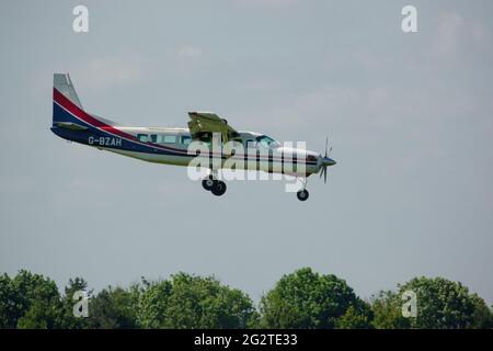 Una grande carovana cessna 208B torna a terra su una pista di erba dopo aver abbandonato il team di visualizzazione del paracadute Red Devils Foto Stock