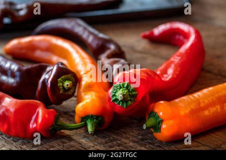 I peperoni Colorul Poivron sono stati prepati su un tavolo di legno per la tostatura in forno Foto Stock