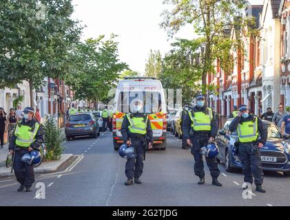 Londra, Regno Unito. 12 giugno 2021. La polizia di Riot blocca una strada residenziale in Shepherd's Bush durante la protesta della Giustizia per la Palestina. Migliaia di persone hanno marciato a Londra per chiedere giustizia alla Palestina e hanno invitato il G7 a porre fine alla cooperazione militare con Israele e ad imporre sanzioni. (Credit: Vuk Valcic / Alamy Live News). Foto Stock