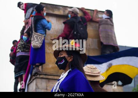 La popolazione indigena Misak assume la piazza del 'Monumento a los Reyes Catolicos'. In questa specifica piazza si trovavano le sculture di Cristoforo Colombo e Isabel la Catolica, giorni prima che tentassero di abbattere queste sculture e di ritorcerle dalla polizia nazionale colombiana. Le sculture sono state abbattere dal ministero della cultura la notte dopo gli scontri. A Bogotà, Colombia, il 11 giugno 2021. Foto Stock