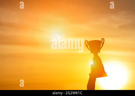 Il vincitore vince il premio trofeo concetto campione. La squadra migliore vince la coppa di premio del campionato per la sfida del campione professionista. Silhouette mani Foto Stock