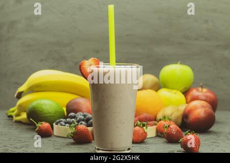 La frutta è posata sulla tavola di frullato di frutta. Cocktail di frutta con frutti di bosco su un tavolo di legno. Sfondo con spazio per il testo Foto Stock