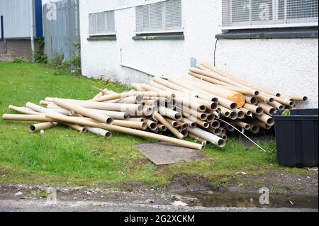 Tubi di cartone e rifiuti scaricati all'esterno dell'edificio Foto Stock