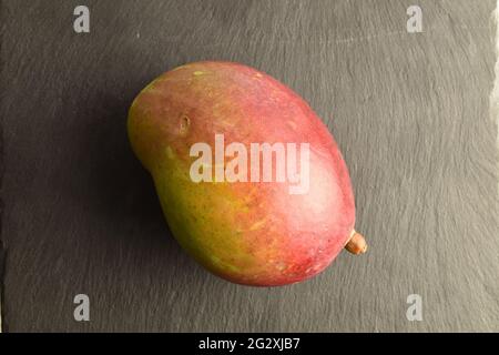 Mango succoso, primo piano, su una tavola di ardesia, vista dall'alto. Foto Stock