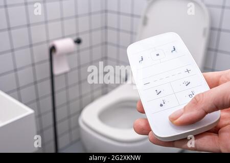 Telecomando con pulsanti del recipiente del water intelligente. wc a filo moderno e automatico ad alta tecnologia Foto Stock
