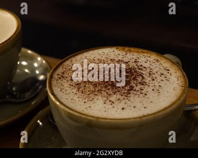 Un cappuccino ben condito in una tazza verde Foto Stock