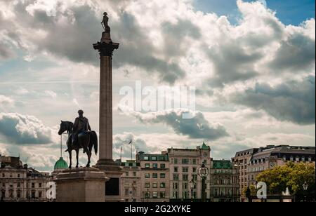 La statua di Re Giorgio IV e la colonna Nelson in Piazza Trafalgar, in autunno pomeriggio. Gli edifici di Whitehall sono sullo sfondo. Foto Stock