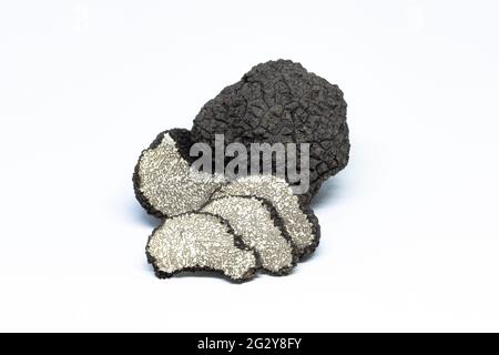 tartufo nero, tuber aestivum, tagliato, a fette, aperto, fotografato su uno sfondo bianco Foto Stock