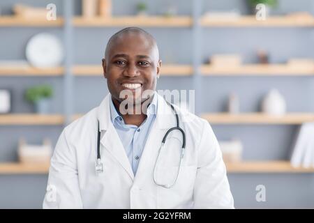Medico online, assistenza sanitaria a distanza. afroamericano uomo in camice bianco con stetoscopio in ufficio interno in clinica Foto Stock