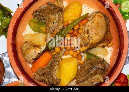 Tradizionale piatto berbero Couscous con carne, patate, ceci, zucchine e sugo di carne servito nella Tajine Foto Stock
