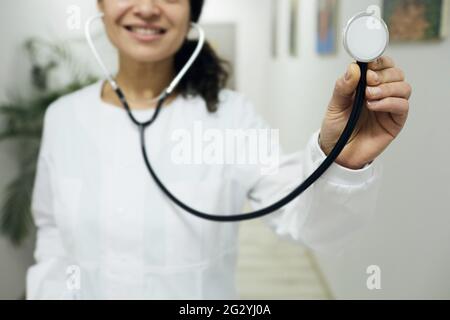 occupazione medica. Donna medico generico che indossa un cappotto medico con stetoscopio in mano, in piedi in una clinica medica, ritratto Foto Stock