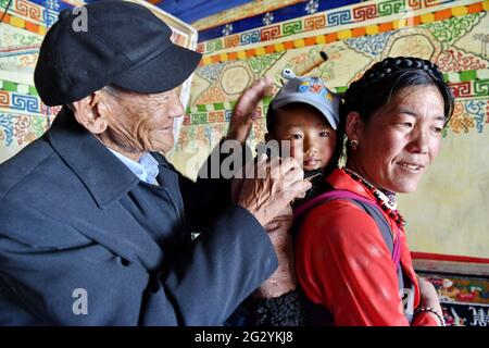 (210613) -- LHASA, 13 giugno 2021 (Xinhua) -- Migmar (L) è visto con i suoi membri della famiglia nel villaggio di Lhaya, Township di Gyamco, Contea di Namling della città di Xigaze, regione Autonoma del Tibet della Cina sudoccidentale, 18 aprile 2021. Il Migmar, di 79 anni, è nato nella contea di Sa'gya di Xigaze e ora vive nel villaggio di Lhaya. Nel ricordare la sua vita da serf prima della riforma democratica del 1959, Migmar disse: "La mia famiglia era fortemente indebitata in quel periodo, quindi sono stato mandato in gregge per un proprietario di serf a pagare i debiti della mia famiglia quando avevo solo sette anni". Lì ha sofferto continuamente di punizione Foto Stock